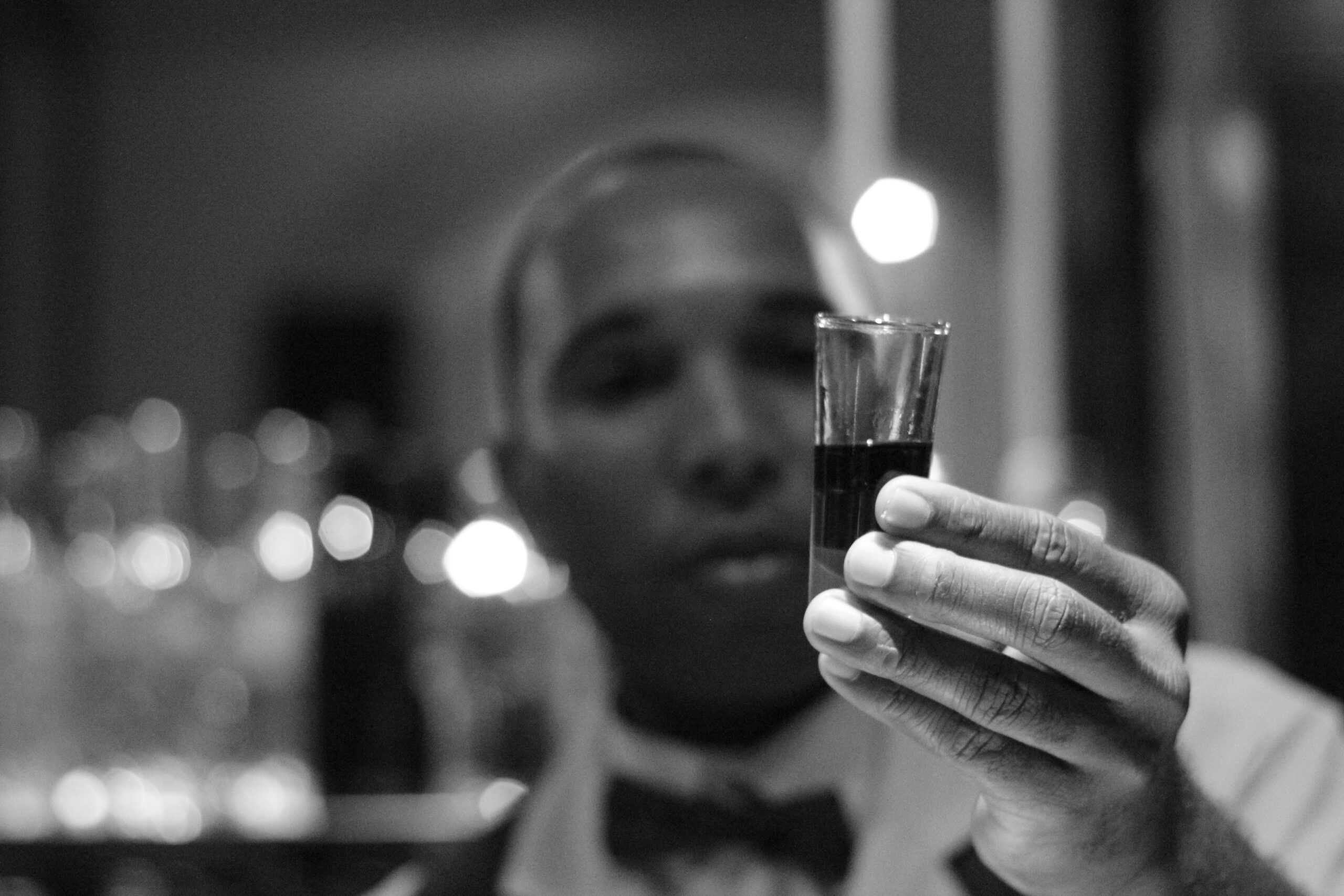 man looking at liqueur in shot glass